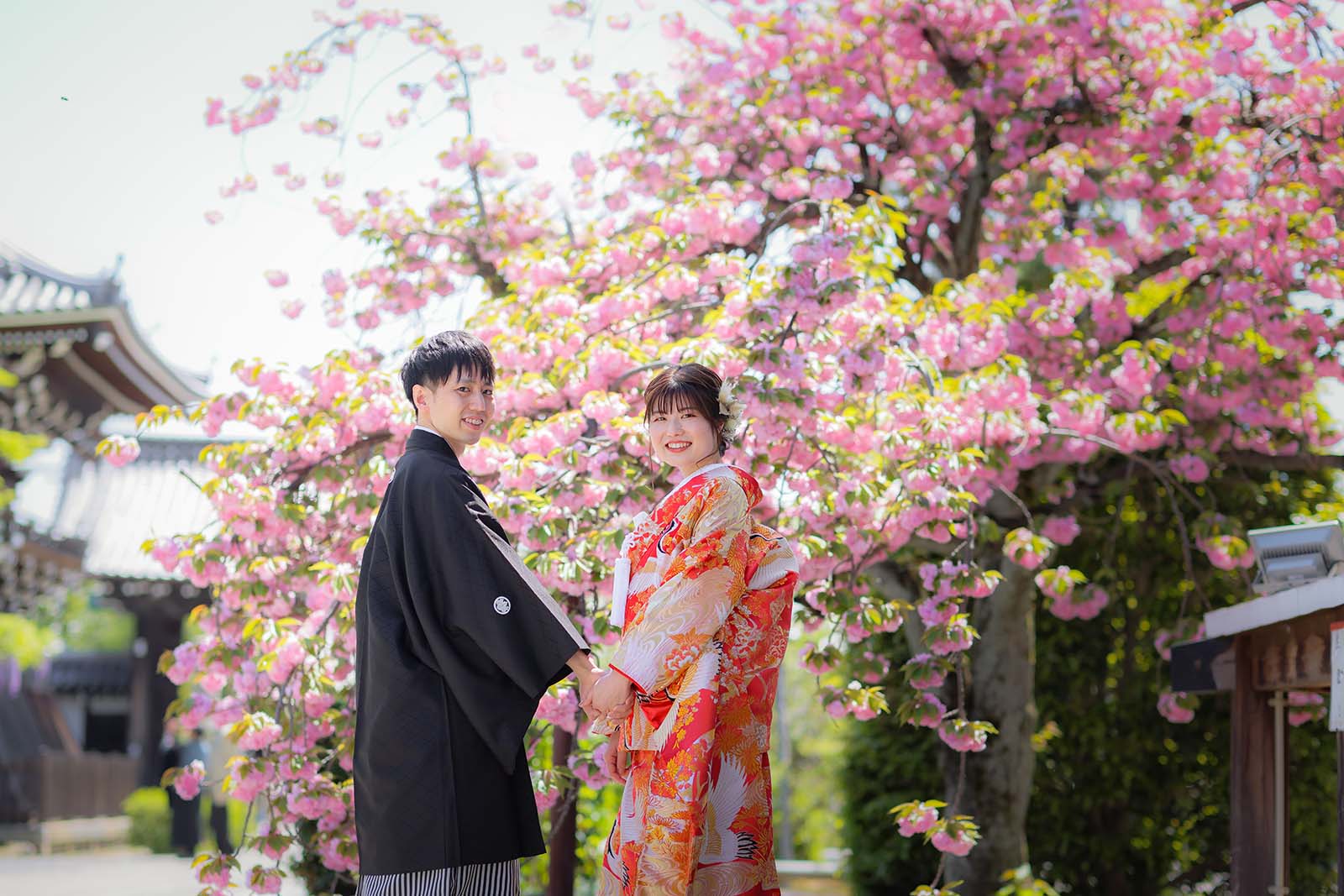 八重桜を背景に笑顔の20代の花嫁様