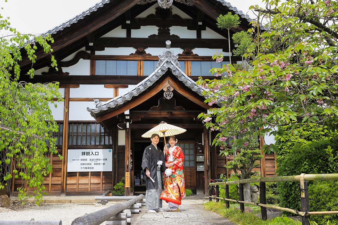 京都のお寺の本堂前にて和傘を使った結婚写真