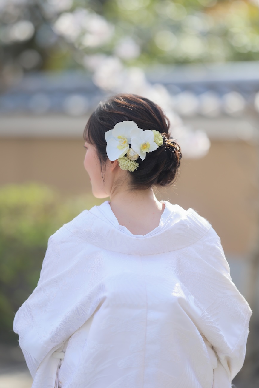 桜を背景に胡蝶蘭を使用した和装ヘアメイクのお写真