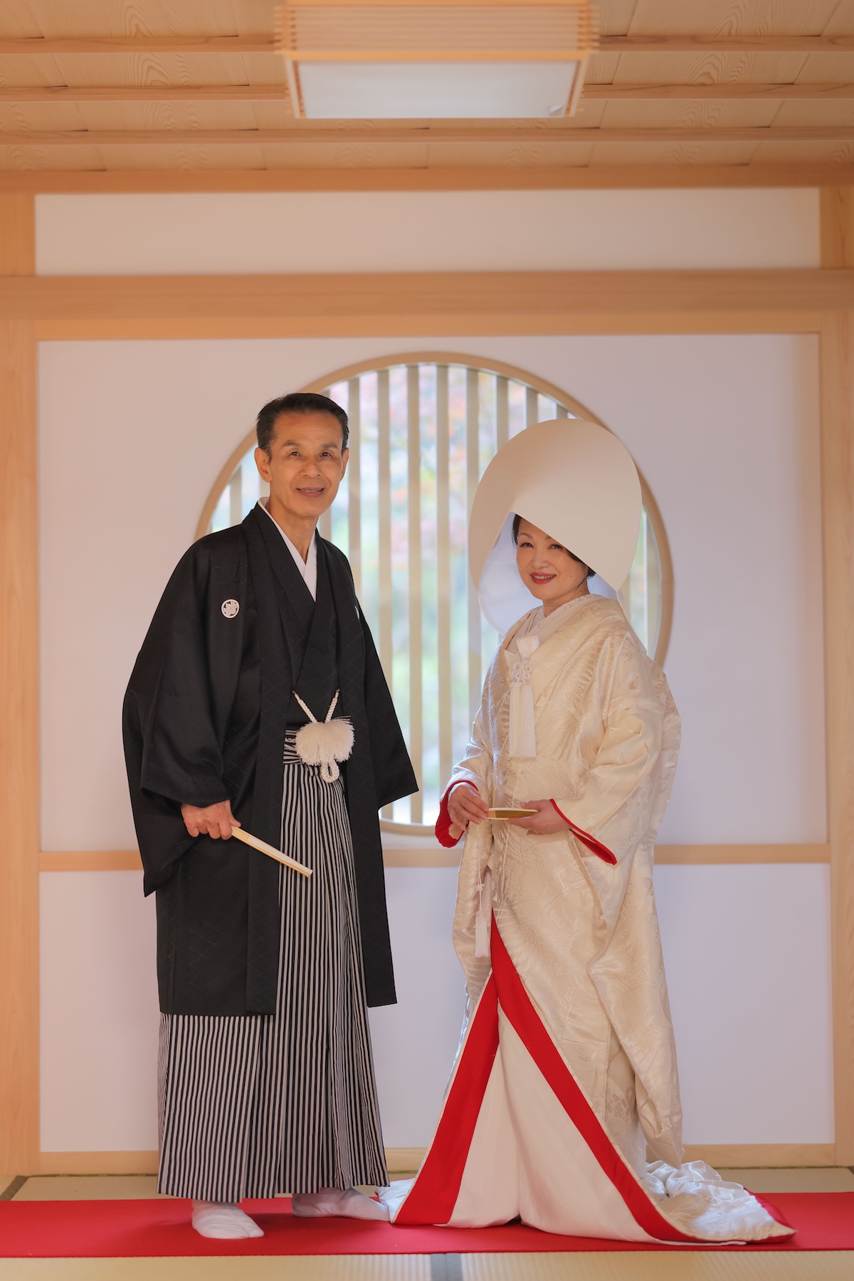 円窓前での綿帽子姿の新郎新婦様。