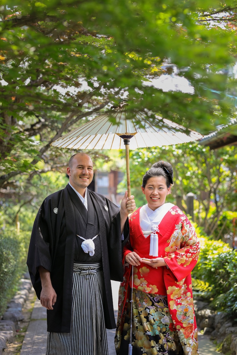 赤と黒の色打掛を着た国際結婚のお客様の記念写真