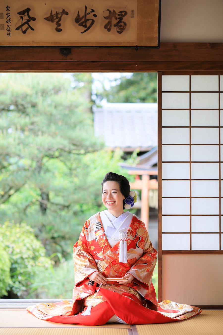 京都戒光寺様のお庭で新緑を背景に笑顔の花嫁様