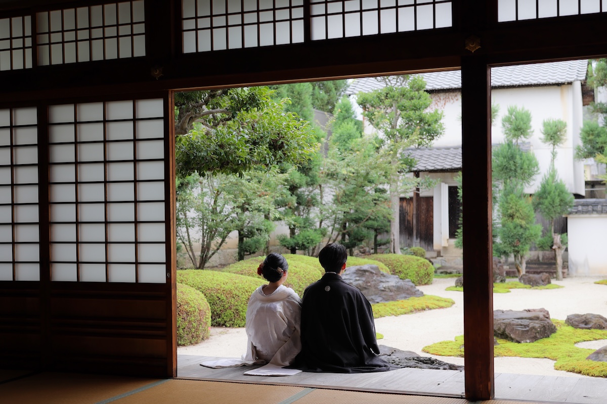 雨の枯山水を背景にした後ろ姿のウェディングフォト