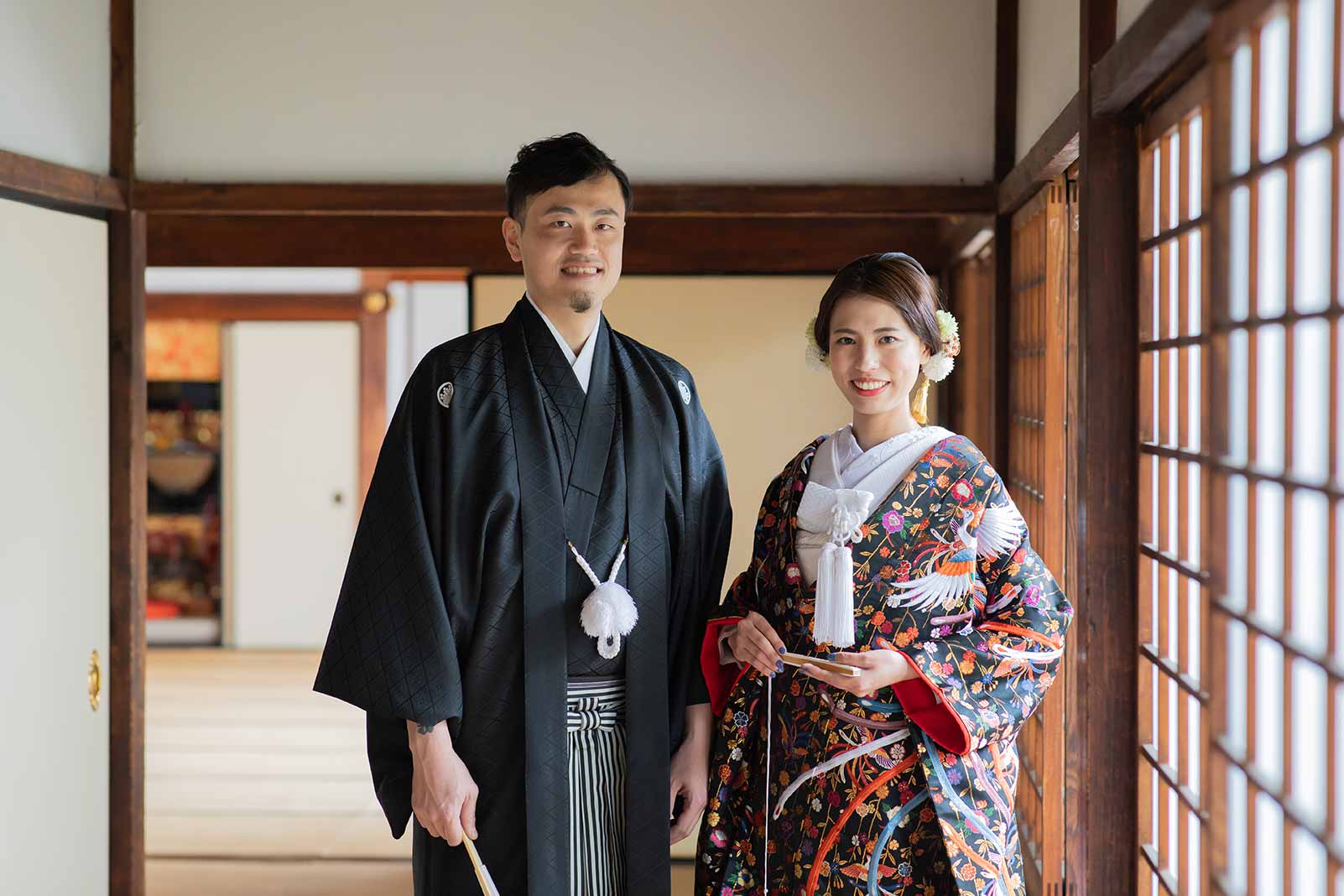 お寺の縁側で黒い色打掛と羽織袴のご夫婦様