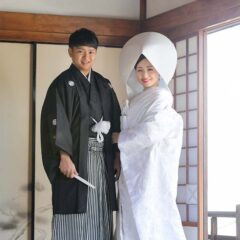 白無垢綿帽子姿で腕を組む新郎新婦様