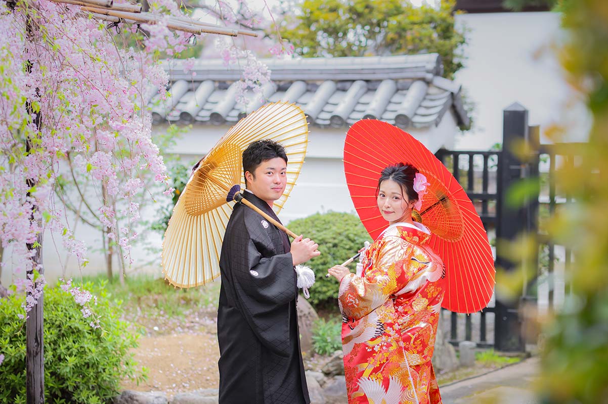 桜の下で番傘を使ったウェディングフォト