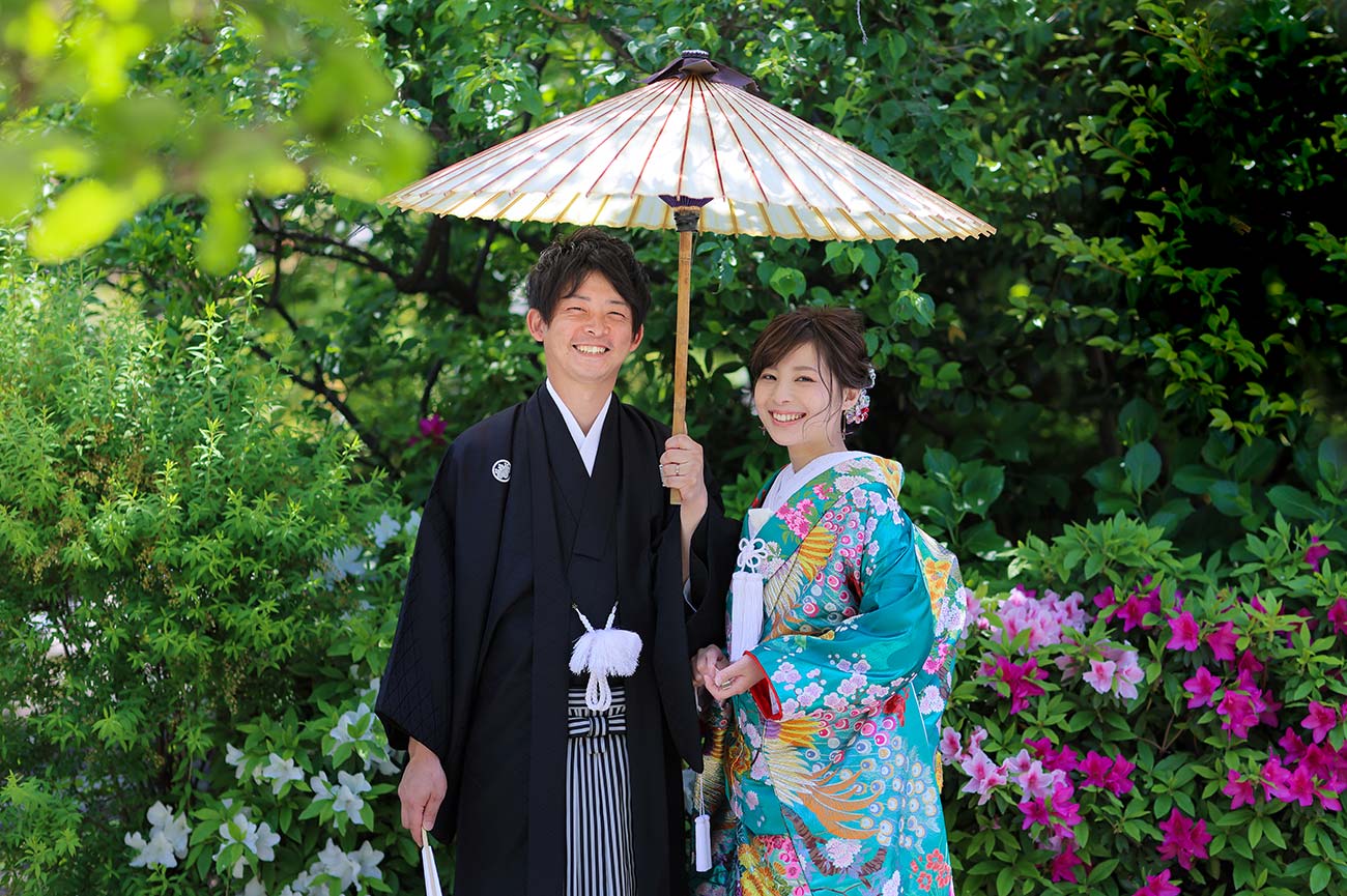 ツツジを背景に番傘を使った結婚記念写真