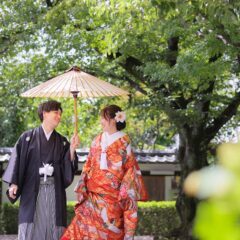 番傘を使って笑顔で歩く新郎新婦様