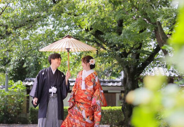 番傘を使って笑顔で歩く新郎新婦様