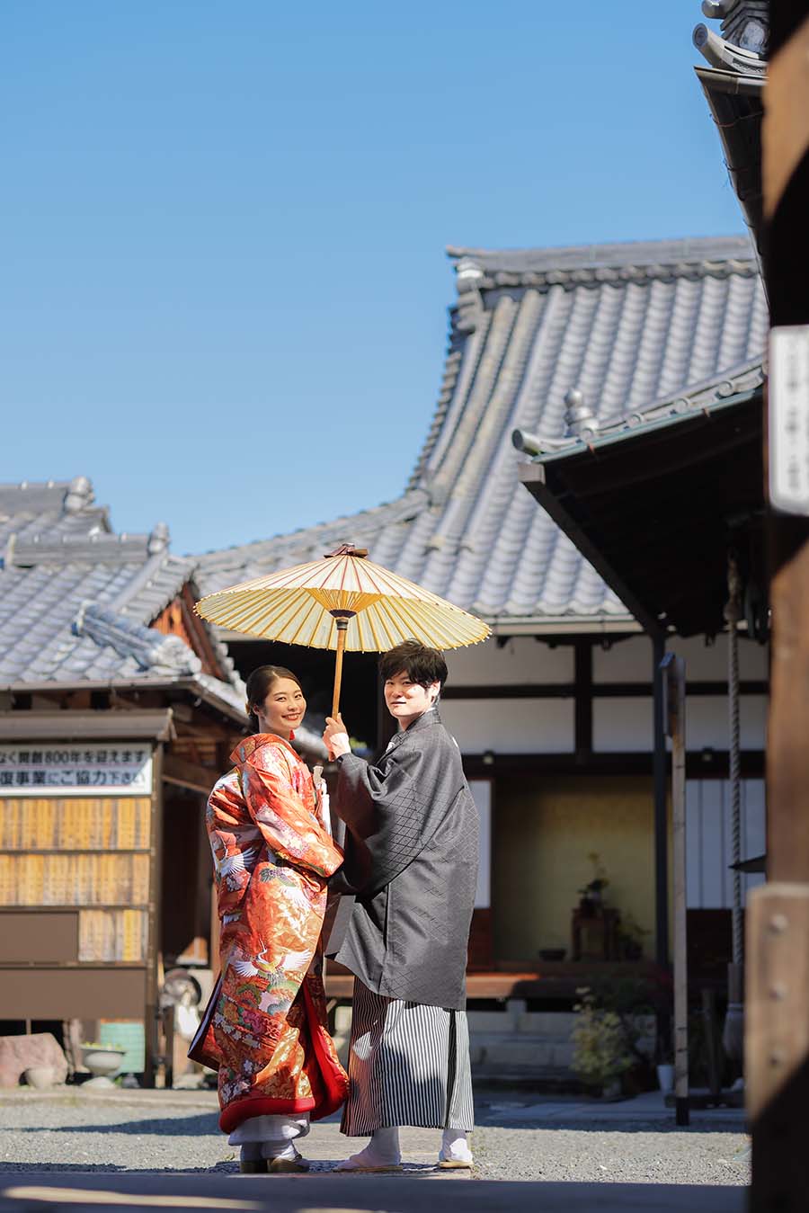秋の京都で番傘を持った和装の新郎新婦様