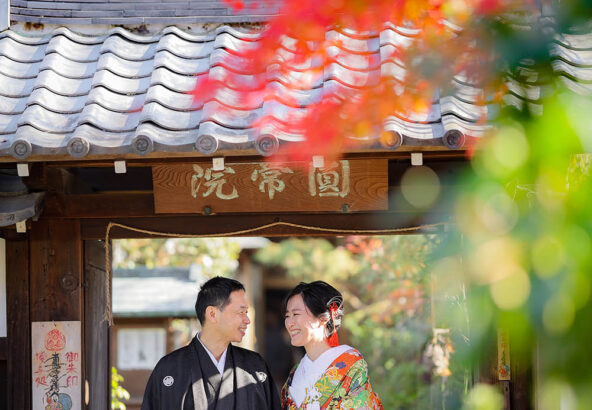12月の紅葉と和装でにこやかに笑顔の新郎新婦様