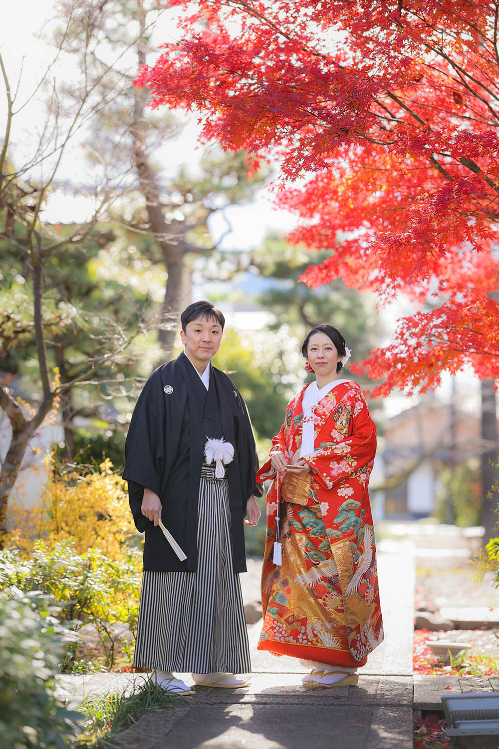 12月の京都の紅葉を背景に立ち姿の新郎新婦様